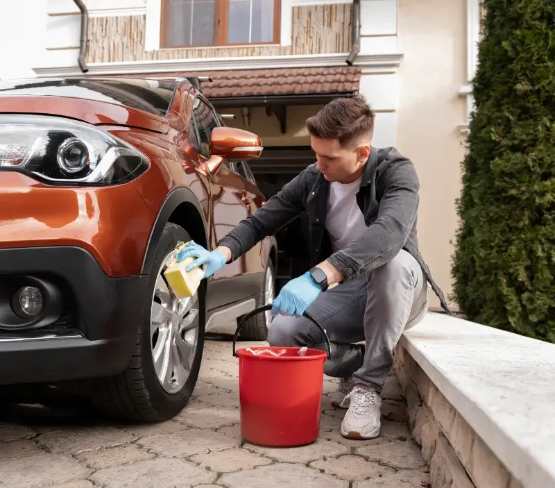 Lavage auto à domicile Nissan-lez-Enserune : professionnel intervenant sur un véhicule